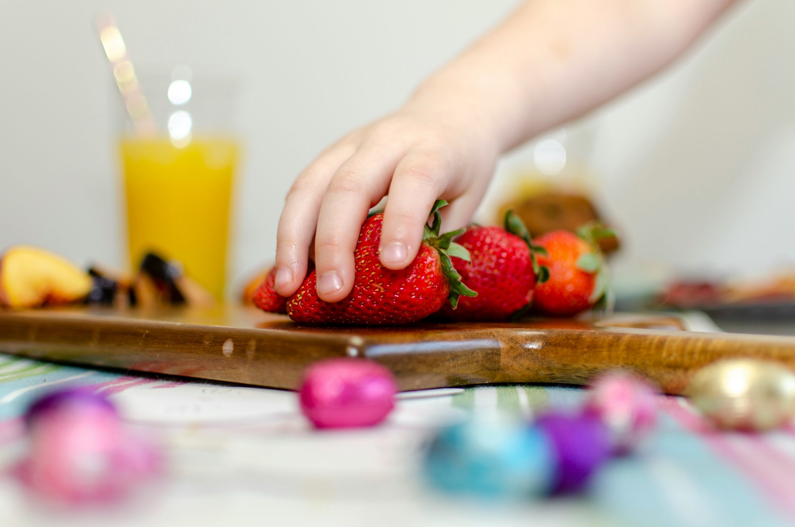 Child's hand on strawberries